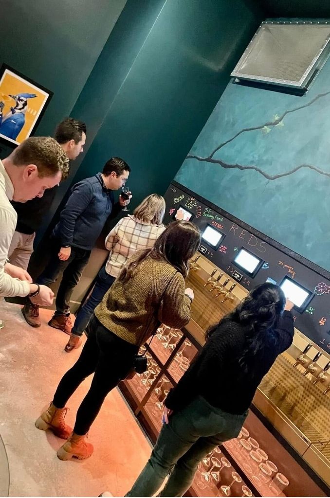 People using the wine bar tap system to select drinks at JBiRD